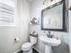 Charming half bath with a modern pedestal sink, decorative mirror, and stylish fixtures at 21502 E Idyllwilde Dr, Parker, CO 80138