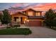 Beautiful two-story home with a well-maintained lawn and inviting covered front porch at sunset at 21502 E Idyllwilde Dr, Parker, CO 80138