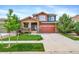 Inviting two-story home featuring a covered front porch and well-manicured lawn on a sunny day at 21502 E Idyllwilde Dr, Parker, CO 80138