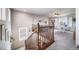 Upper landing area with wood railing, leading to additional rooms with ample natural light at 21502 E Idyllwilde Dr, Parker, CO 80138