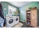 Well-organized laundry room with a modern washer and dryer, storage and shelving, and a window at 21502 E Idyllwilde Dr, Parker, CO 80138