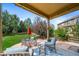 Spacious covered patio with comfortable seating and a view of the landscaped backyard at 21502 E Idyllwilde Dr, Parker, CO 80138