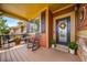 Cozy covered front porch with seating, plants, and a decorative wreath on the front door at 21502 E Idyllwilde Dr, Parker, CO 80138