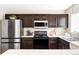 Stylish kitchen with stainless steel refrigerator and appliances with dark cabinets at 4128 S Riviera St, Aurora, CO 80018