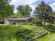 Charming home featuring a lush lawn, wood accents, and a well-manicured garden at 78 Fairway Ln, Littleton, CO 80123
