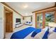 Bright primary suite with wood trim, sitting area, television, and access to a private balcony at 78 Fairway Ln, Littleton, CO 80123