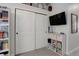 Bedroom featuring a closet with bi-fold doors, entertainment center, and a bookcase at 1885 S Quebec Way # D22, Denver, CO 80231