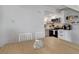 Bright dining area with view to the kitchen featuring white cabinets and stainless steel appliances at 1885 S Quebec Way # D22, Denver, CO 80231