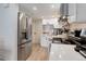 Modern kitchen with stainless steel refrigerator, white cabinets, quartz countertops and appliances at 1885 S Quebec Way # D22, Denver, CO 80231