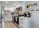 Bright kitchen featuring white cabinets, stainless steel appliances, and stylish gray subway tile backsplash at 1885 S Quebec Way # D22, Denver, CO 80231