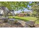 Expansive backyard with a wooden deck, lush greenery, mature trees, and unique garden features and plenty of shade at 6708 W Portland Ave, Littleton, CO 80128