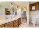 Bathroom with walk-in shower, wooden vanity, and tiled walls at 6708 W Portland Ave, Littleton, CO 80128
