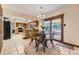 Bright dining area with sliding glass doors, view of kitchen with wooden cabinets and tile flooring at 6708 W Portland Ave, Littleton, CO 80128