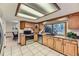 Well-lit kitchen with wood cabinets, stainless steel appliances, and tile flooring at 6708 W Portland Ave, Littleton, CO 80128