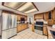 Kitchen featuring stainless steel appliances, wood cabinets, and tile flooring at 6708 W Portland Ave, Littleton, CO 80128