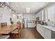 Bright kitchen with white cabinets, stainless steel appliances, and a rustic wood dining table at 5428 Suffolk Ave, Castle Rock, CO 80104