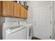 Efficient laundry room featuring modern washer and dryer, upper cabinets, and a convenient door for accessibility at 5428 Suffolk Ave, Castle Rock, CO 80104