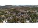 Scenic aerial view showcasing a neighborhood with snow covered ground and mature evergreen trees at 3064 Elk View Dr, Evergreen, CO 80439