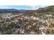 Panoramic aerial view of the homes nestled among the trees with snow-capped mountains in the background at 3064 Elk View Dr, Evergreen, CO 80439