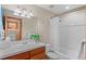 Bright bathroom with tile surround bathtub and shower, single sink and lighting at 3064 Elk View Dr, Evergreen, CO 80439