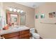 Well-lit bathroom featuring a single sink vanity, a toilet, a shower, and decorative wall art at 3064 Elk View Dr, Evergreen, CO 80439
