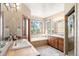Bright bathroom featuring a large soaking tub, double vanity, walk-in shower and tile floors at 3064 Elk View Dr, Evergreen, CO 80439