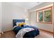 Comfortable bedroom with a plush bed, a large window with outdoor views, and warm, inviting decor at 3064 Elk View Dr, Evergreen, CO 80439