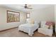 Bedroom featuring a bed, sitting chair, and two windows with wood trim at 3064 Elk View Dr, Evergreen, CO 80439