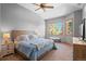 Primary bedroom featuring a large window, a tray ceiling, a ceiling fan and neutral-toned walls and carpet at 3064 Elk View Dr, Evergreen, CO 80439