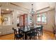 Formal dining room featuring a large wood table with seating for eight, a stylish chandelier and natural light at 3064 Elk View Dr, Evergreen, CO 80439