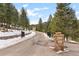 Private gated entrance with stone pillars and signage amidst a scenic wooded landscape at 3064 Elk View Dr, Evergreen, CO 80439