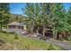 Beautiful home exterior showcasing a three-car garage, lush landscaping, and a welcoming covered porch at 3064 Elk View Dr, Evergreen, CO 80439
