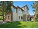 Stunning exterior showcasing stone accents, large windows, and a well-maintained lawn with mature trees at 3064 Elk View Dr, Evergreen, CO 80439