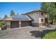 Beautiful home exterior featuring a three-car garage, solar panels, and a well-maintained driveway at 3064 Elk View Dr, Evergreen, CO 80439
