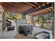 Outdoor patio featuring a hot tub with a lift, stone pillars, and views of the surrounding trees at 3064 Elk View Dr, Evergreen, CO 80439