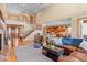 Open-concept living area showcases seamless flow, a fireplace, and a staircase leading to the upper level at 3064 Elk View Dr, Evergreen, CO 80439