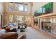 Sun-filled living room boasts soaring ceilings, a cozy fireplace, and large windows with scenic views at 3064 Elk View Dr, Evergreen, CO 80439