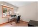 Bright office space with a wooden desk, an office chair, and a large window with snow-covered outdoor views at 3064 Elk View Dr, Evergreen, CO 80439