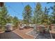 Outdoor deck with a grill, comfortable seating, dining area, and beautiful views of surrounding trees at 3064 Elk View Dr, Evergreen, CO 80439