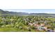 An aerial view of the neighborhood showcasing the natural beauty of rolling hills and lush trees at 229 Berthoud Way, Golden, CO 80401