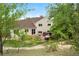 Serene backyard with a hot tub, patio seating, and views of mature trees at 229 Berthoud Way, Golden, CO 80401