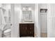 Bright bathroom featuring a dark wood vanity with a white countertop and a decorative mirror at 229 Berthoud Way, Golden, CO 80401