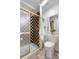 Updated bathroom with a glass-enclosed shower featuring checkered tiling and white beadboard paneling at 229 Berthoud Way, Golden, CO 80401