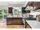 Updated kitchen features stainless steel appliances, dark brown cabinets, and a window overlooking the backyard at 229 Berthoud Way, Golden, CO 80401