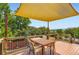 Outdoor deck with a sunshade, table, and chairs offering lovely views of the surrounding greenery at 702 Windmill Pl, Highlands Ranch, CO 80126