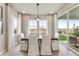 Bright dining area with a wooden table and white chairs with large windows offering outdoor views at 3352 N Buchanan Way, Aurora, CO 80019