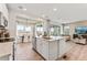 Modern kitchen with island, open floorplan, and natural light shining through the windows at 3352 N Buchanan Way, Aurora, CO 80019