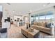 Bright, open-concept living room featuring hardwood floors and large windows with sliding glass doors to the exterior at 3352 N Buchanan Way, Aurora, CO 80019