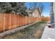 A fully-fenced backyard features a well maintained lawn and a view of the home at 5086 N Raleigh St, Denver, CO 80212