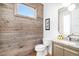 Charming half-bath with rustic wood accent wall, modern fixtures, and granite countertop vanity at 5086 N Raleigh St, Denver, CO 80212